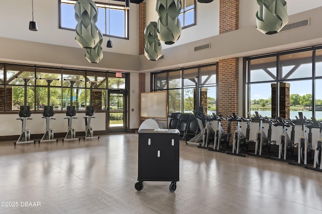 workout area with a water view and a towering ceiling