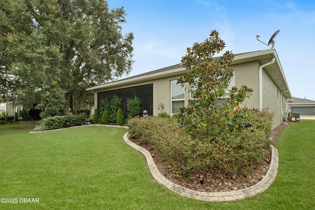 view of side of property with central AC unit and a lawn