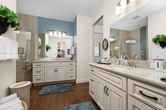 bathroom with hardwood / wood-style flooring, walk in shower, and vanity