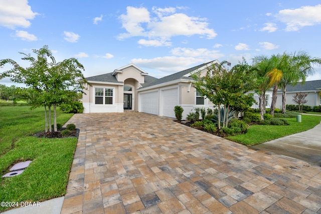 view of front of property with a garage and a front lawn