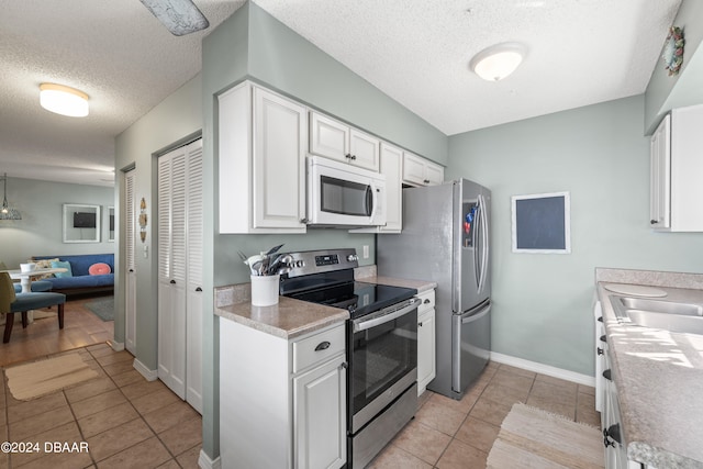 kitchen featuring white cabinetry, stainless steel appliances, and a textured ceiling