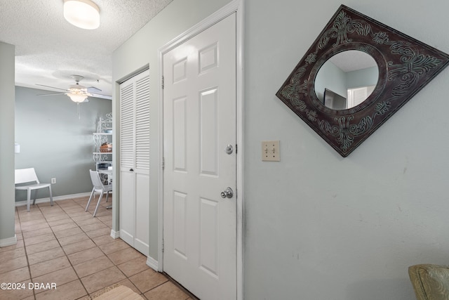 hallway featuring a textured ceiling and light tile patterned floors