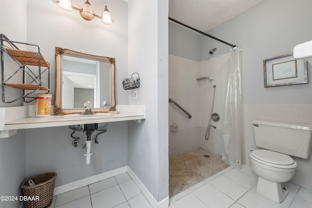 bathroom with curtained shower, tile patterned flooring, a textured ceiling, and toilet