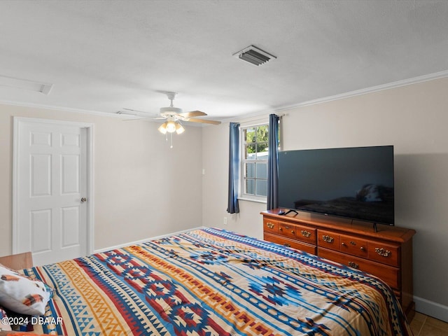 bedroom with baseboards, visible vents, attic access, ceiling fan, and crown molding