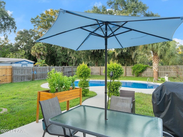 view of patio with area for grilling, a fenced in pool, outdoor dining area, and a fenced backyard