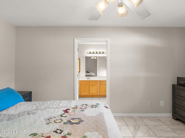 bedroom with a ceiling fan, baseboards, a sink, marble finish floor, and connected bathroom