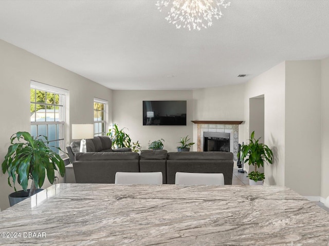 living area with visible vents and a tiled fireplace