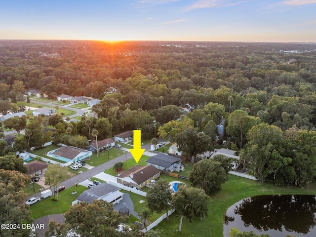 bird's eye view featuring a wooded view, a residential view, and a water view