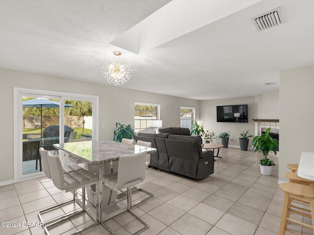 dining area featuring light tile patterned floors, visible vents, a notable chandelier, and a healthy amount of sunlight