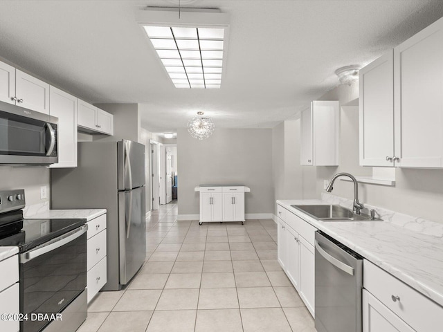 kitchen with white cabinets, stainless steel appliances, light countertops, and a sink