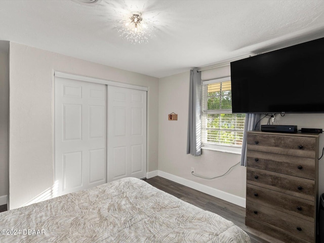 bedroom featuring a closet, baseboards, and wood finished floors