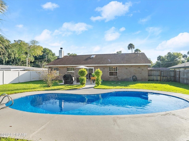 view of swimming pool featuring a fenced backyard, a patio, and a yard