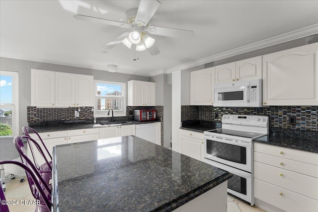 kitchen featuring white cabinetry, electric stove, and a wealth of natural light