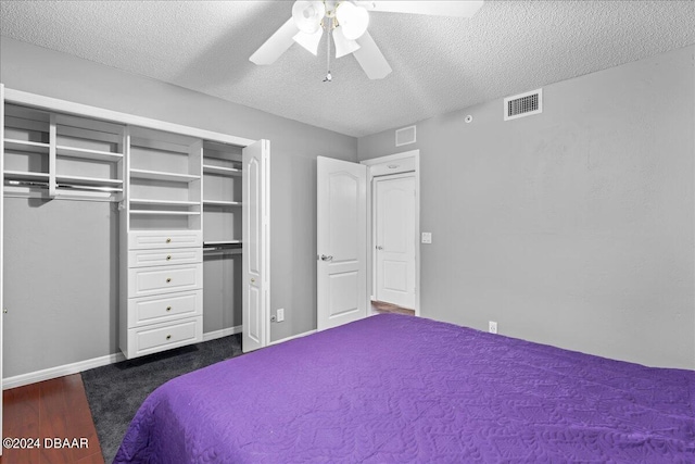 bedroom featuring ceiling fan, dark hardwood / wood-style floors, a closet, and a textured ceiling