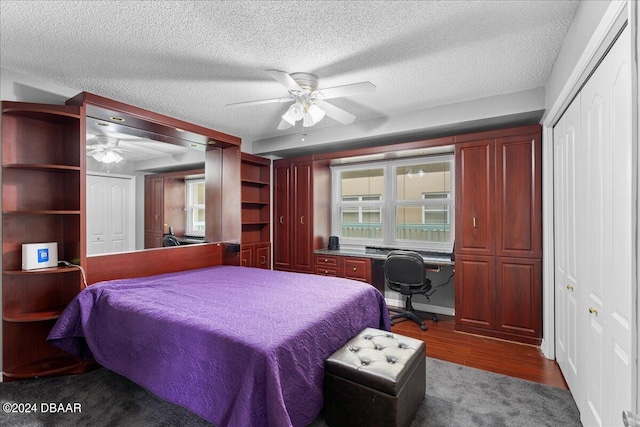 bedroom with wood-type flooring, built in desk, ceiling fan, and a textured ceiling