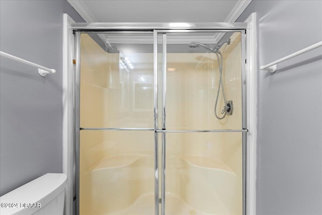 bathroom featuring toilet, an enclosed shower, and crown molding