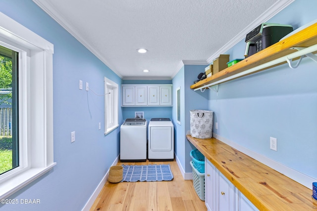 2300 Lake Ruby Rd, Deland, FL 32724 - laundry room featuring cabinet space, ornamental molding, washer and dryer, baseboards, and light wood finished floors