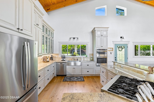 2300 Lake Ruby Rd, Deland, FL 32724 - kitchen with stainless steel appliances, a sink, high vaulted ceiling, light wood-style floors, and light stone counters