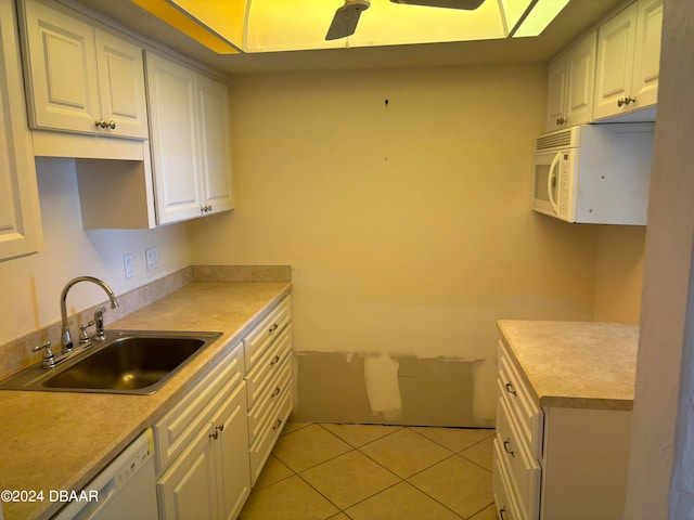 kitchen featuring light tile patterned floors, white appliances, white cabinetry, and sink