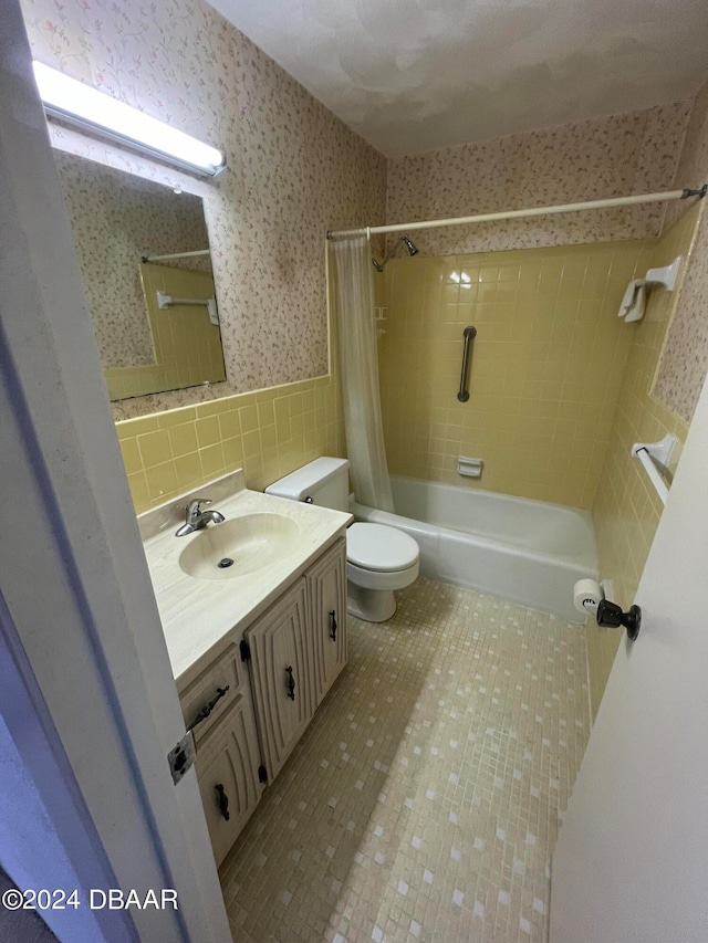 full bathroom featuring shower / tub combo with curtain, vanity, tile walls, and toilet