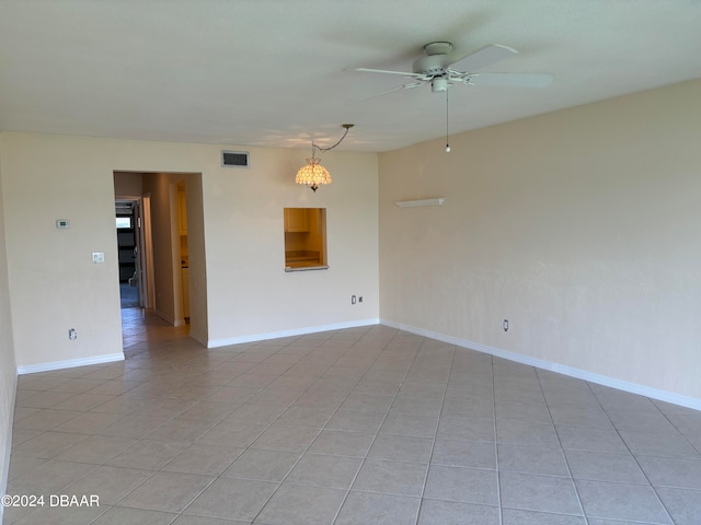 spare room with light tile patterned floors and ceiling fan with notable chandelier