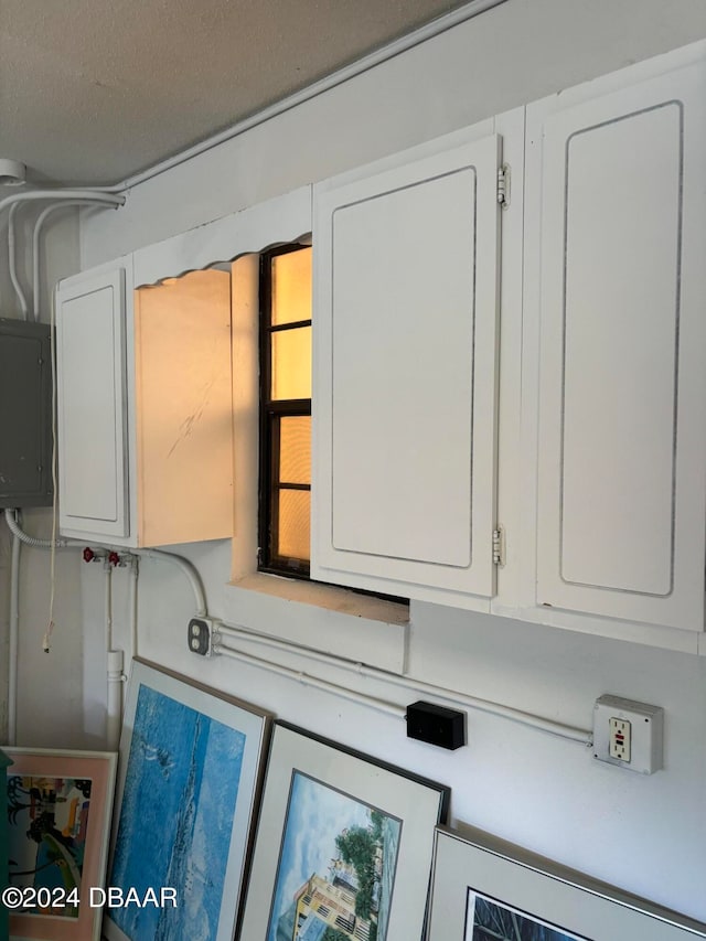 room details featuring electric panel and a textured ceiling