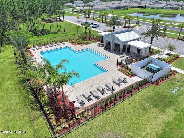 view of swimming pool with a water view, a yard, and a patio area