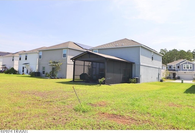 back of property with a garage, a sunroom, and a yard