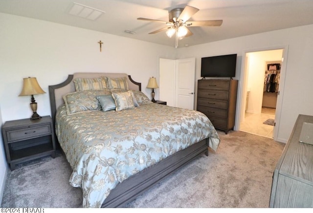 bedroom featuring a spacious closet, carpet floors, ceiling fan, and a closet