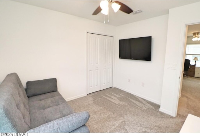 living area with ceiling fan and light carpet