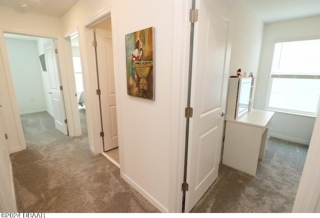 hallway featuring dark colored carpet