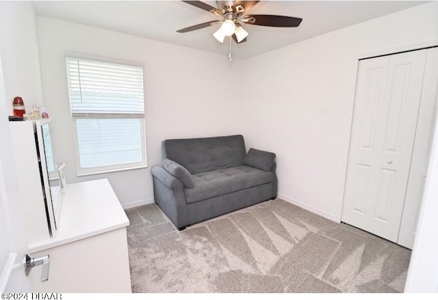 living area featuring ceiling fan and light colored carpet