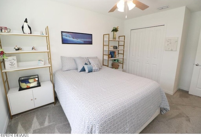 bedroom with ceiling fan, light carpet, and a closet