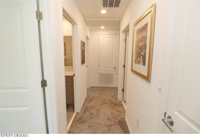 hallway featuring light colored carpet