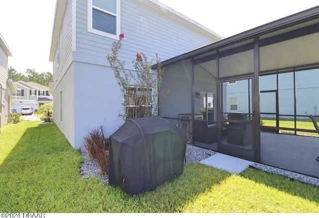 view of side of property featuring a sunroom and a yard