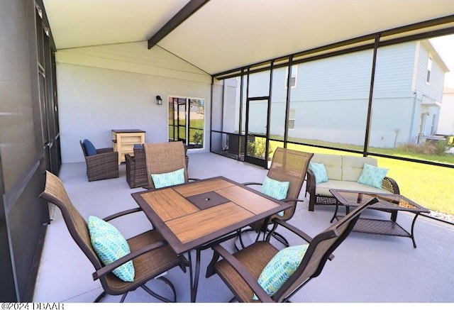 sunroom / solarium featuring vaulted ceiling with beams