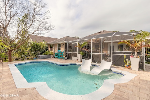 view of pool with a hot tub, a patio area, and glass enclosure