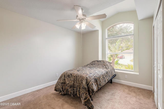 carpeted bedroom with multiple windows, vaulted ceiling, and ceiling fan