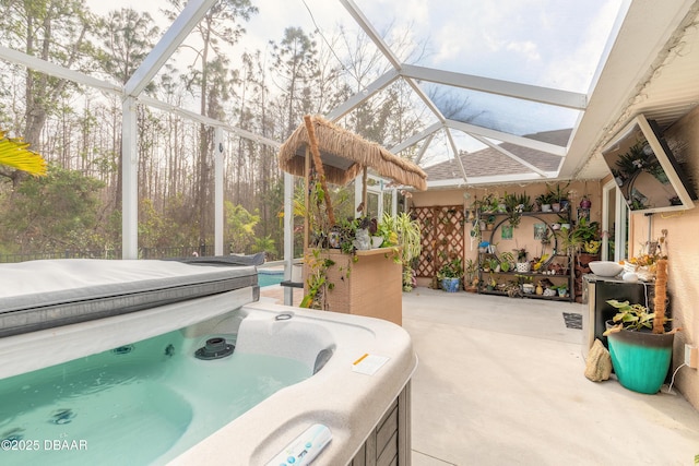 view of patio featuring a hot tub and glass enclosure