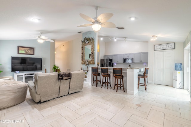 living room featuring vaulted ceiling and ceiling fan