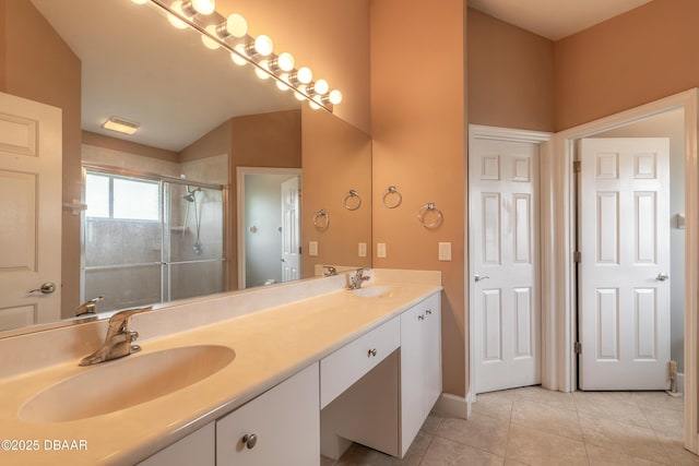 bathroom with tile patterned flooring, vanity, vaulted ceiling, and a shower with shower door