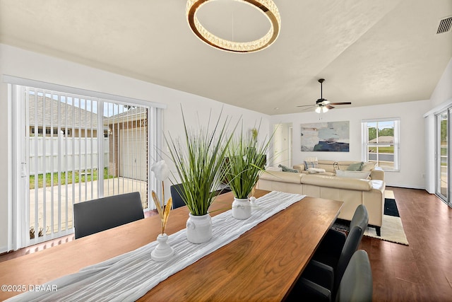 dining room with dark wood finished floors, vaulted ceiling, and a ceiling fan