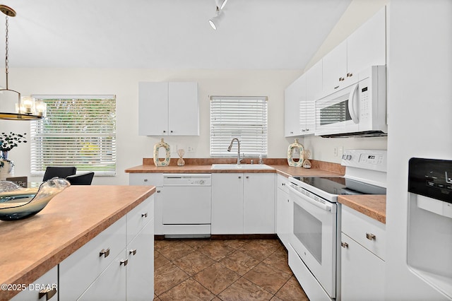 kitchen featuring white appliances, a sink, a chandelier, healthy amount of natural light, and lofted ceiling