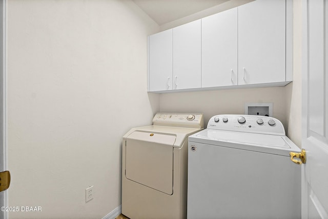 laundry area featuring cabinet space, washer and clothes dryer, and baseboards