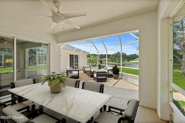 sunroom featuring outdoor lounge area, a ceiling fan, and a water view