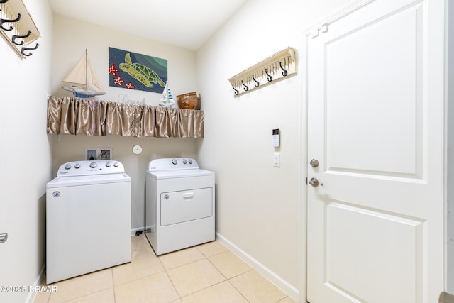 laundry area featuring light tile patterned flooring and washing machine and clothes dryer