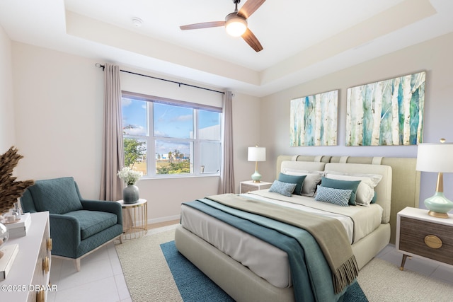 tiled bedroom with a tray ceiling and ceiling fan