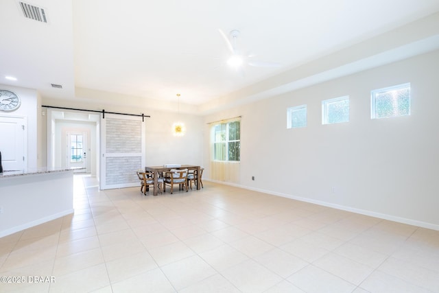 spare room featuring a barn door, plenty of natural light, and light tile patterned flooring