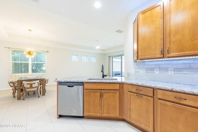 kitchen featuring light stone countertops, dishwasher, hanging light fixtures, and sink