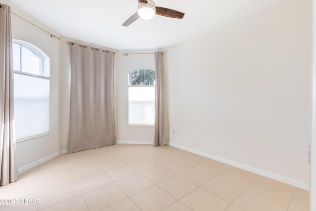 tiled empty room featuring ceiling fan